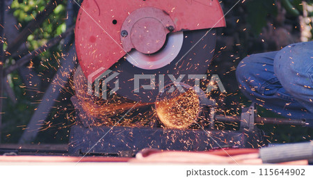 Welding machine iron metal sparking. Hot flame welding metal work cutting fire iron workshop. Locksmith using Welding machine cutting metal processing grinder. Close up hands Sparks in metalworking Welding machine iron metal sparking. Hot flame welding metal work cutting fire iron workshop. Locksmith using Welding machine cutting metal processing grinder. Close up hands Sparks in metalworking 115644902