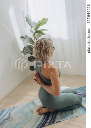 A 50-year-old woman does yoga at home A 50-year-old woman does yoga at home 115644918
