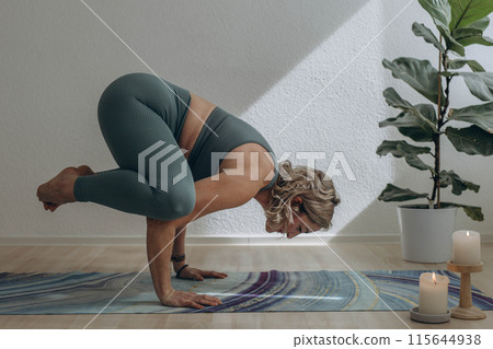 A 50-year-old woman does yoga at home A 50-year-old woman does yoga at home 115644938