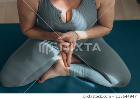 A 50-year-old woman does yoga at home A 50-year-old woman does yoga at home 115644947