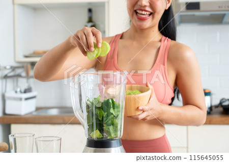 A cropped image of a fit and healthy Asian woman making a green smoothie in the kitchen. A cropped image of a fit and healthy Asian woman making a green smoothie in the kitchen. 115645055