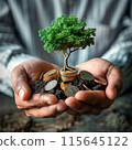 A man holds coins in his hands and a tree grows from coins 115645122