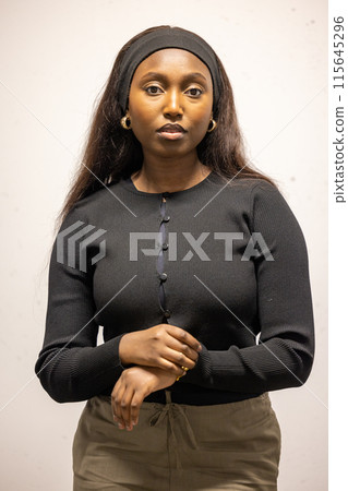 Confident woman with headband poses for a professional portrait, looking at camera Confident woman with headband poses for a professional portrait, looking at camera 115645296