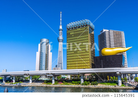 Tokyo cityscape in Japan. Contrails (left)... View of Tokyo Skytree and contrails against the blue sky from Azumabashi Bridge = 3rd 115645391