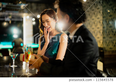 Men and women drinking at a bar 115645578