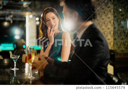 Men and women drinking at a bar 115645579