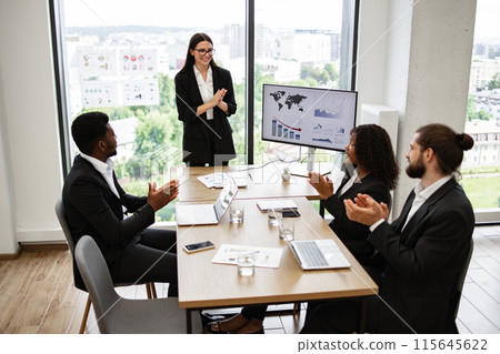 Business presentation with diverse team applauding in modern office 115645622