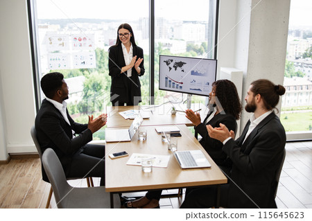 Businesswoman presenting report to diverse colleagues in modern office 115645623