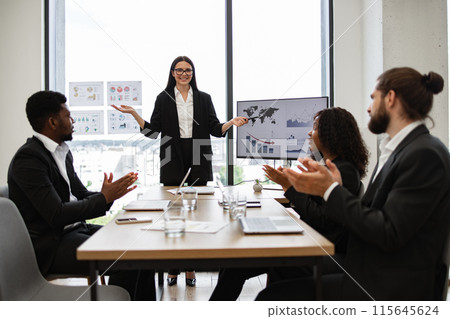 Business woman presenting report to diverse colleagues in modern office 115645624