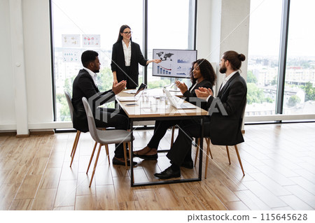 Caucasian business woman giving a presentation to diverse colleagues Caucasian business woman giving a presentation to diverse colleagues 115645628