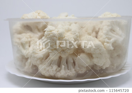 The cauliflower lies in a plastic bowl of water. Washing vegetables before cooking. The cauliflower lies in a plastic bowl of water. Washing vegetables before cooking. 115645720