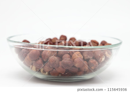 Hazelnuts in a glass bowl isolated on a white background. Proper nutrition, diet. Hazelnuts in a glass bowl isolated on a white background. Proper nutrition, diet. 115645936
