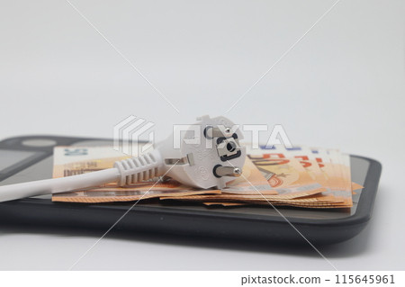 White electric cable and banknotes lie on a kitchen scale, expensive electricity saving electricity. 115645961