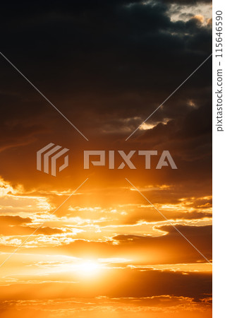 Natural Bright Dramatic Sky In Sunset Dawn Sunrise. Amazing Bold Golden Sunset Sunrise Sky Background. Warm Yellow And Orange Colors. Dark Clouds with Sun Natural Bright Dramatic Sky In Sunset Dawn Sunrise. Amazing Bold Golden Sunset Sunrise Sky Background. Warm Yellow And Orange Colors. Dark Clouds with Sun 115646590
