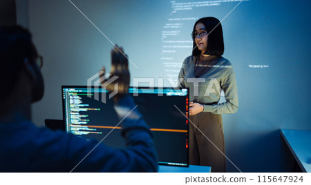 trainee developer hand up to ask speaker about software coding project presentation at night in office 115647924