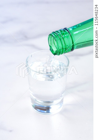 將韓國燒酒（一種韓國傳統蒸餾酒）倒入玻璃杯中 115648234