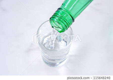 Pouring soju, a traditional Korean distilled alcoholic drink, into a glass 115648240