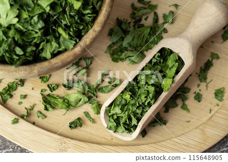 Dry parsley spice with wooden spoon in wooden bowl. Homegrown herbs and spices for cooking. Fresh dried aromatic natural food ingredients Dry parsley spice with wooden spoon in wooden bowl. Homegrown herbs and spices for cooking. Fresh dried aromatic natural food ingredients 115648905