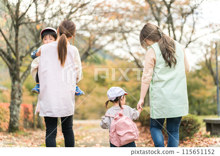 Nursery teacher woman and kindergarten child (nursery school / kindergarten nurse) walking / excursion in autumn park Nursery teacher woman and kindergarten child (nursery school / kindergarten nurse) walking / excursion in autumn park 115651152