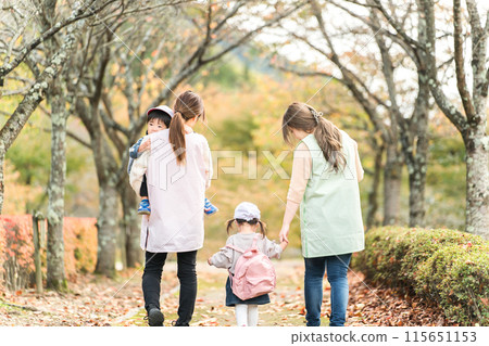 Nursery teacher woman and kindergarten child (nursery school / kindergarten nurse) walking / excursion in autumn park 115651153