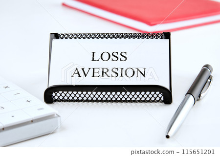 Business concept. The inscription Loss Aversion on a business card on a white background Business concept. The inscription Loss Aversion on a business card on a white background 115651201