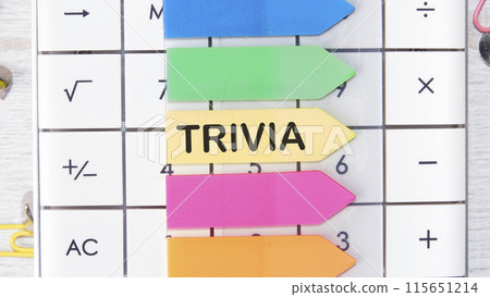 Finance and economics concept. The text is written - TRIVIA on the sticker in the shape of an arrow on the background of a calculator Finance and economics concept. The text is written - TRIVIA on the sticker in the shape of an arrow on the background of a calculator 115651214
