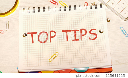 Business concept. Text TOP TIPS in a notebook on the desk of a businessman, manager 115651215