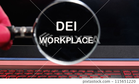 Diversity, equity, inclusion DEI symbol. Words DEI WORKPLACE written text appeared through a magnifying glass on a dim laptop screen Diversity, equity, inclusion DEI symbol. Words DEI WORKPLACE written text appeared through a magnifying glass on a dim laptop screen 115651220