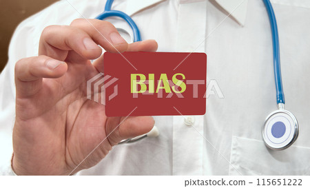 Business bias concept. Word BIAS written on a business card, a card in the hand of a man in a white shirt with a stethoscope around his neck Business bias concept. Word BIAS written on a business card, a card in the hand of a man in a white shirt with a stethoscope around his neck 115651222