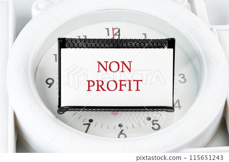 Accounting concept. Text NON PROFIT on a business card on a stand on a lying watch 115651243