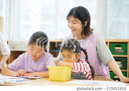 Teachers and students studying drawing at after-school care centers and after-school day care centers. Several elementary school students and a teacher watching over them. 115651918