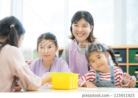 Teachers and students studying at after-school care centers and after-school day care centers, etc. Multiple elementary school students and teachers looking at the camera Teachers and students studying at after-school care centers and after-school day care centers, etc. Multiple elementary school students and teachers looking at the camera 115651925