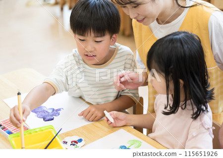 老師和學生在課後和課後日間服務中學習繪畫，多名小學生和老師在旁邊看著他們。 115651926