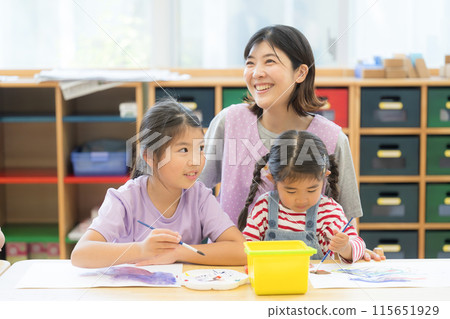 Teachers and students studying at after-school care centers and after-school day care centers, etc. Multiple elementary school students and a teacher watching over them 115651929