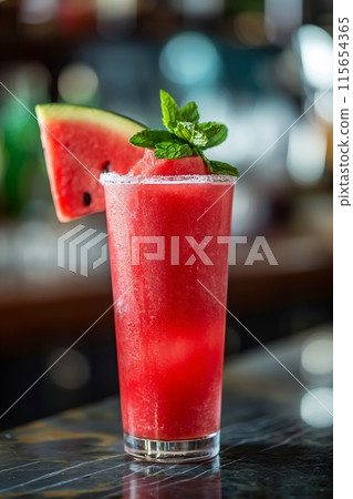 Frosted glass of watermelon juice with ice and mint, perfect for summer refreshment 115654365