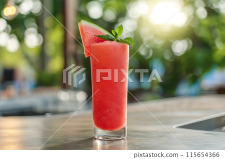 Chilled watermelon cocktail garnished with mint, served outdoors on a sunny day 115654366