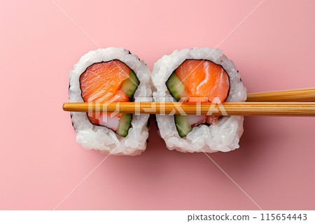 Salmon sushi rolls against a vibrant pink background, classic and tasteful 115654443