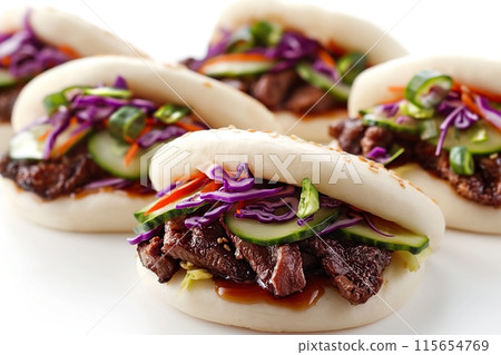 Three beef bao with cucumber and purple cabbage on a white backdrop 115654769