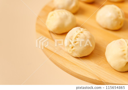 Close-up traditional Central Asian cuisine manty with meat on wooden board, frozen semi-finished products, copy space. Close-up traditional Central Asian cuisine manty with meat on wooden board, frozen semi-finished products, copy space. 115654865