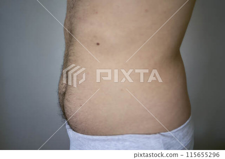 the side and stomach of a thirty-year-old man of average build 115655296