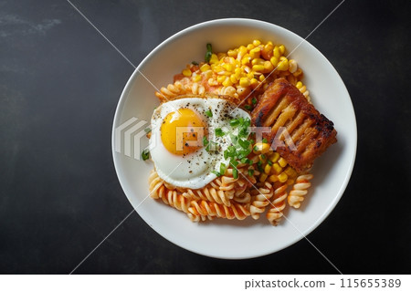 Tasty twisty pasta with fried egg, crispy ham, and sweet corn in a white bowl 115655389