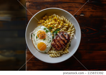 Savory twisty pasta served with a fried egg, ham, and corn on a rustic wooden table 115655392