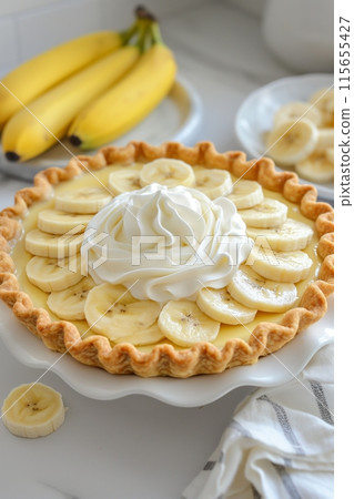 A banana cream pie with a central whipped cream swirl, ready for a festive occasion A banana cream pie with a central whipped cream swirl, ready for a festive occasion 115655427