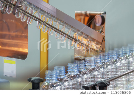 Abstract scene the drinking water bottle manufacturing process by blow mold machine. 115656806