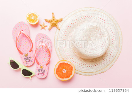 Top view of various seashells placed near colorful fruit and stylish summer accessories on table background. Summer concept. Flat lay. Top view with copy space for text 115657564