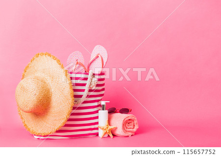 Stylish bag with beach accessories . Summer holiday concept. Top view of beach bag with sunscreen cream with space for text Stylish bag with beach accessories . Summer holiday concept. Top view of beach bag with sunscreen cream with space for text 115657752