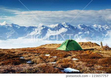 Tent against the backdrop of snow-capped mountain peaks. The view from the mountains to Mount Ushba Mheyer, Georgia. Europe 115657757
