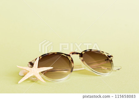 sunglasses with seashell lying on table background. Sunglasses on summer background. Top view flat lay with copy space for text 115658083