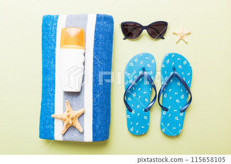 Summer holiday concept. Top view of beach towel, flip flop and sunscreen cream on table Top view with copy space for text 115658105