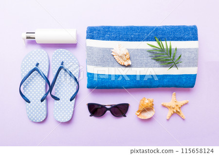 Summer holiday concept. Top view of beach towel, flip flop and sunscreen cream on table Top view with copy space for text 115658124